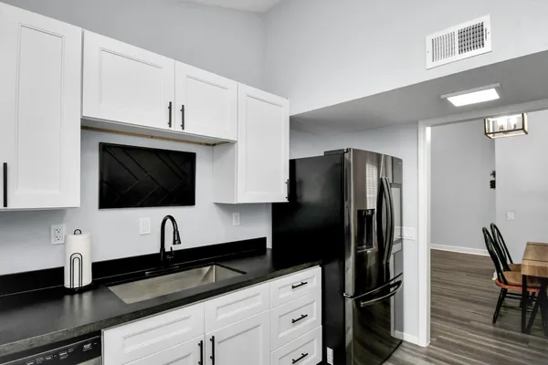 a kitchen with stainless steel appliances white cabinets a sink a stove and a refrigerator