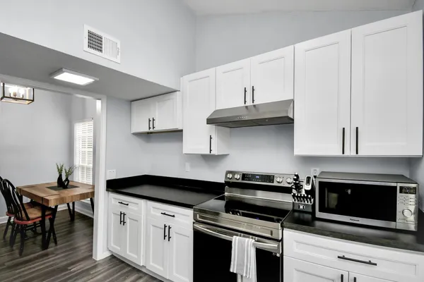 a kitchen with stainless steel appliances a stove a microwave and cabinets