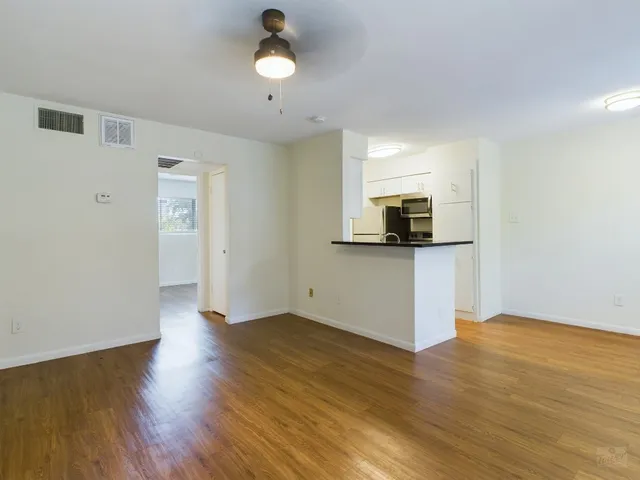 a view of a kitchen with wooden floor and electronic appliances