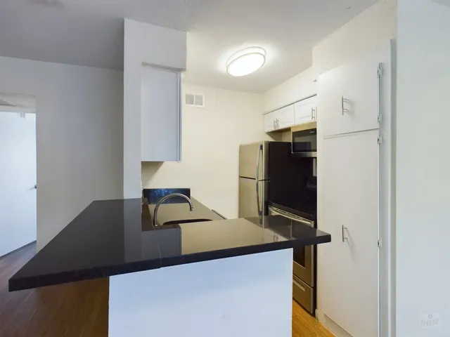 a kitchen with a refrigerator and a stove