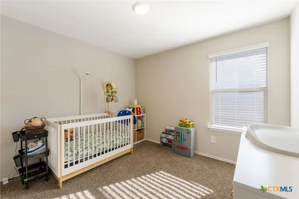 a bedroom with a baby crib and a window