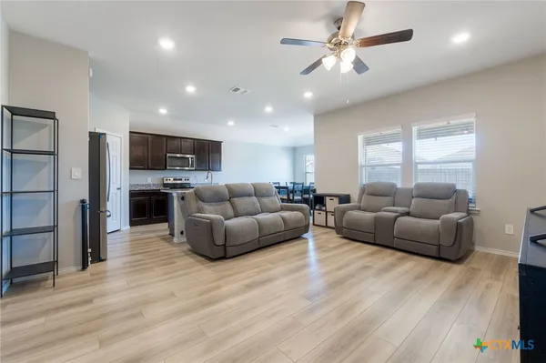 a living room with furniture flat screen tv and window