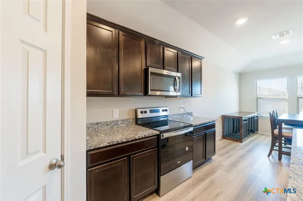 a kitchen with stainless steel appliances granite countertop a sink stove and microwave