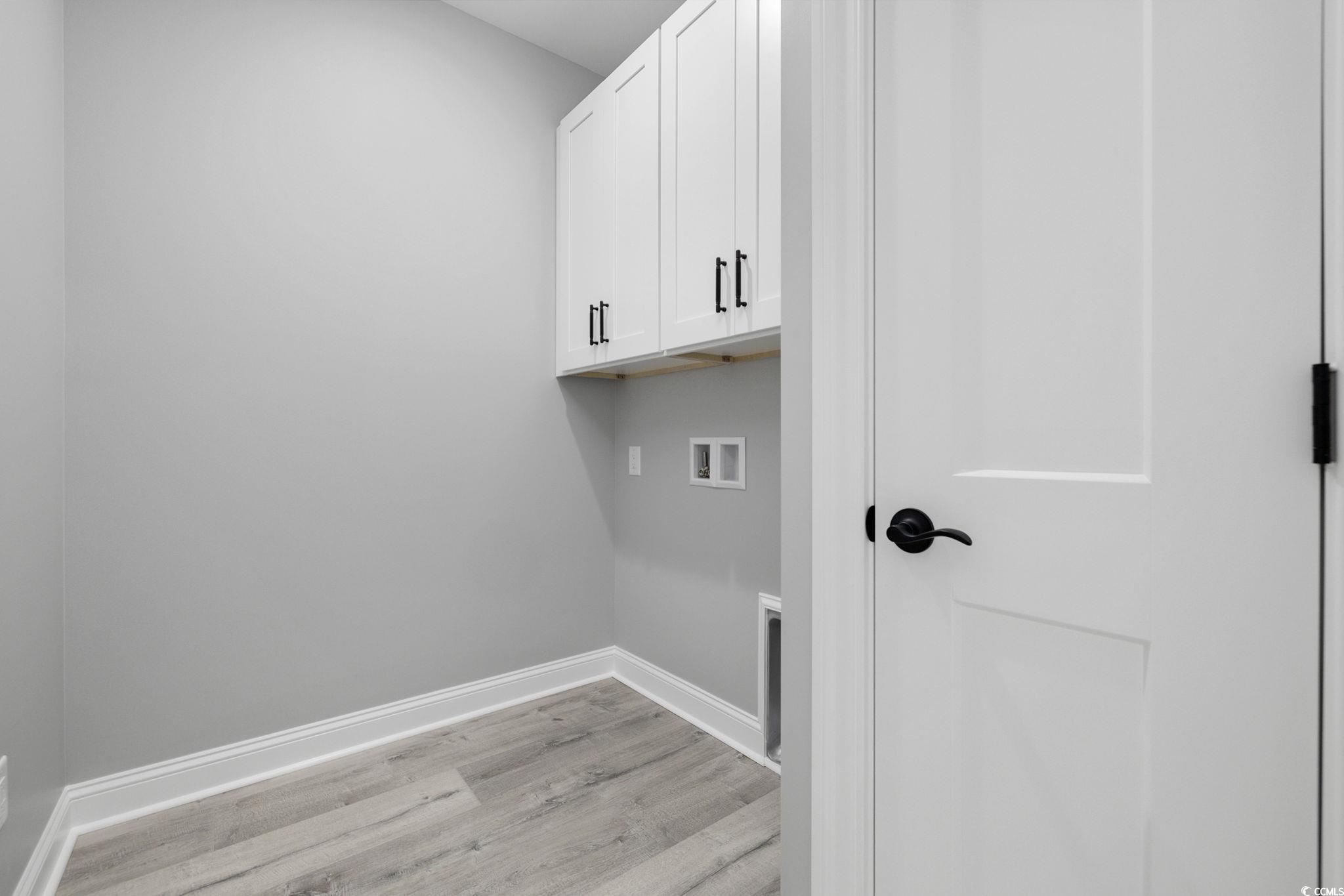 4806 North Kings Highway Myrtle Beach, SC 29577 - Photo 10 of 38 Washroom with washer hookup, light wood finished floors, and cabinet space