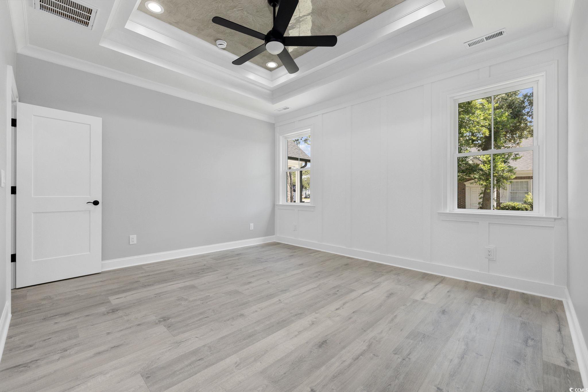 4806 North Kings Highway Myrtle Beach, SC 29577 - Photo 12 of 38 Spare room with light wood-style flooring, crown molding, a tray ceiling, ceiling fan, and recessed lighting