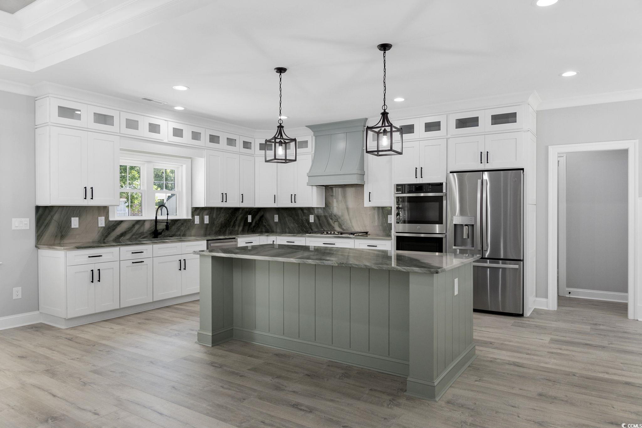 4806 North Kings Highway Myrtle Beach, SC 29577 - Photo 19 of 38 Kitchen with crown molding, stainless steel appliances, recessed lighting, a center island, and custom range hood