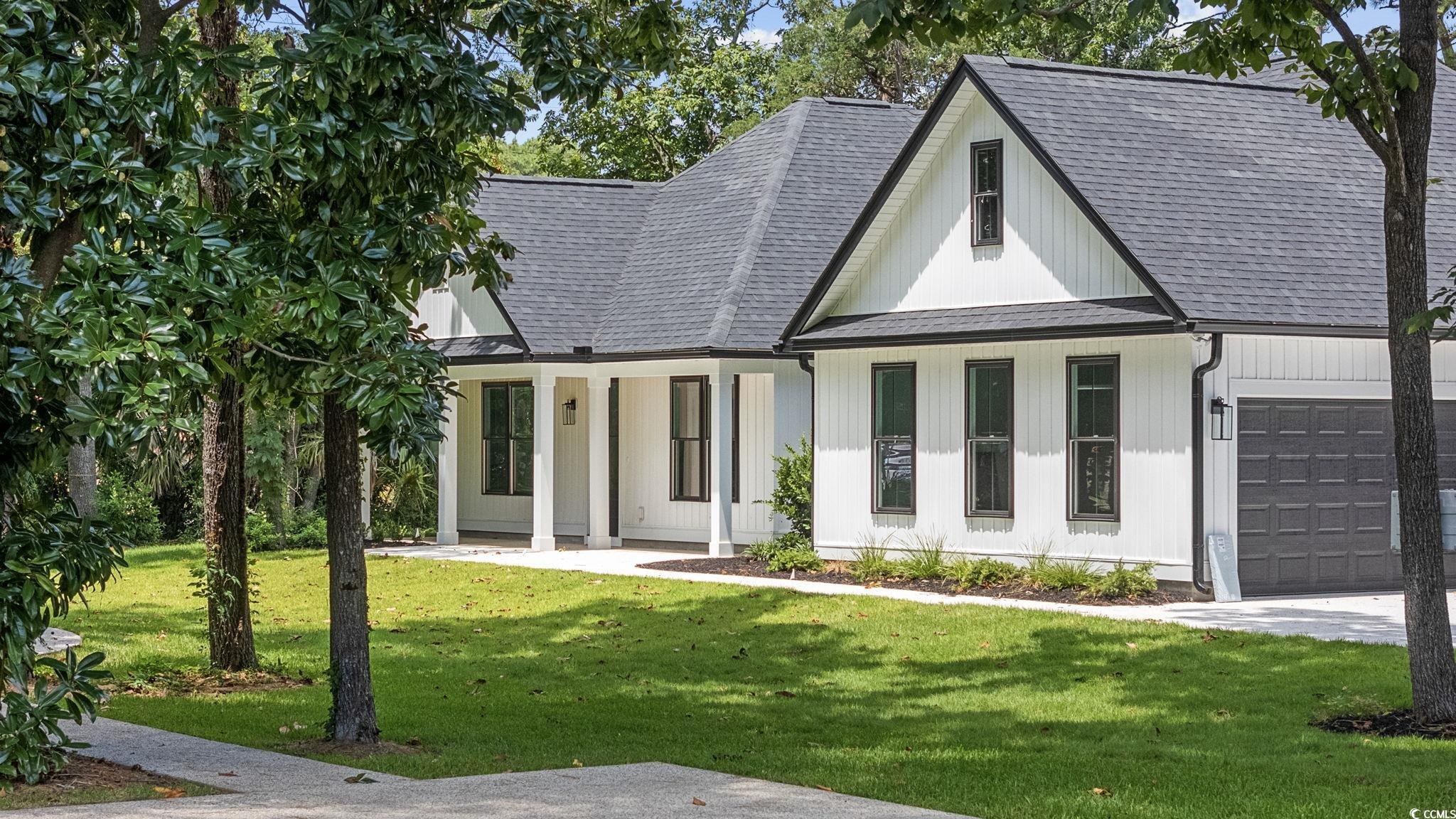 4806 North Kings Highway Myrtle Beach, SC 29577 - Photo 2 of 38 Modern inspired farmhouse with roof with shingles, a front yard, and an attached garage