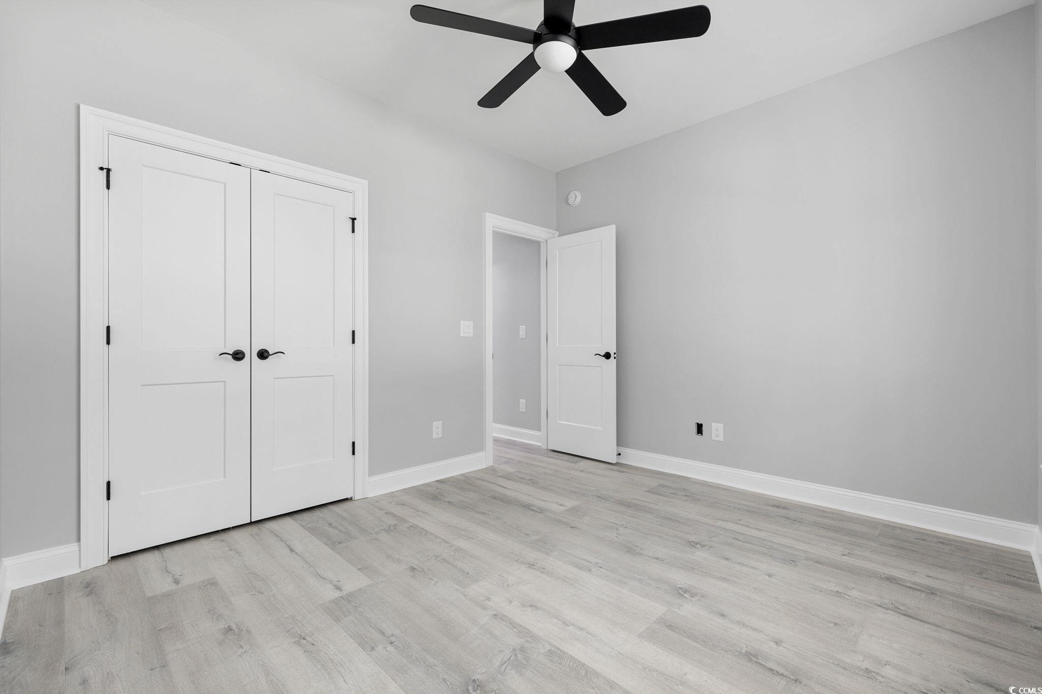 4806 North Kings Highway Myrtle Beach, SC 29577 - Photo 24 of 38 Unfurnished bedroom featuring light wood finished floors, a closet, and a ceiling fan