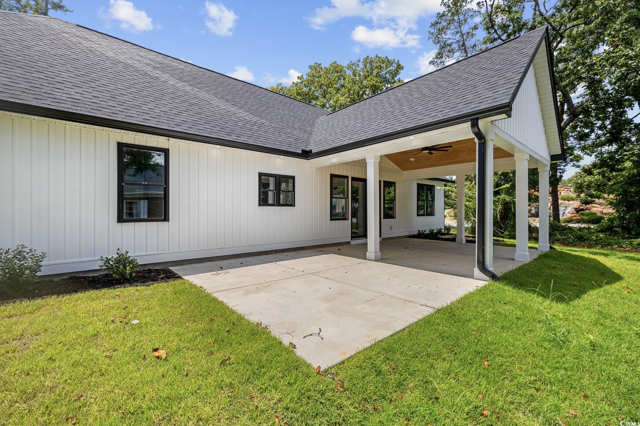 4806 North Kings Highway Myrtle Beach, SC 29577 - Photo 32 of 38 Back of property featuring a shingled roof, a patio area, a ceiling fan, and a lawn