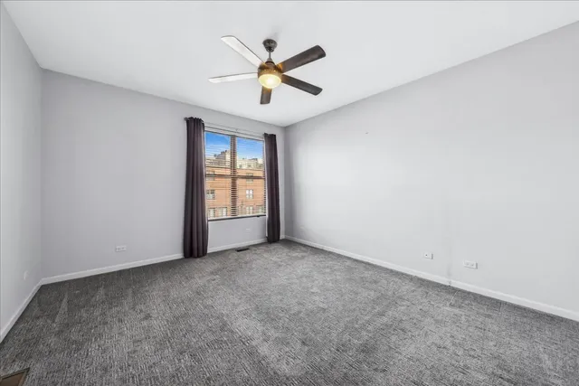 an empty room with closet and a ceiling fan