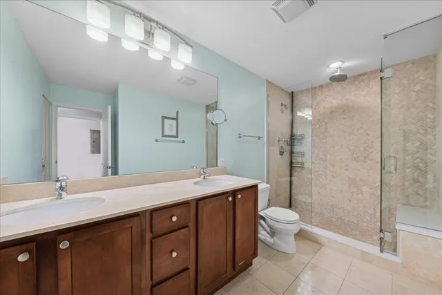 a spacious bathroom with a granite countertop sink toilet mirror and shower