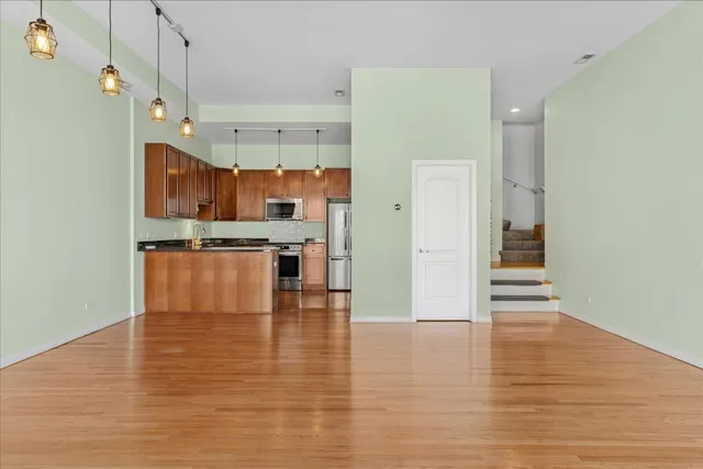 a view of kitchen with wooden floor and electronic appliances