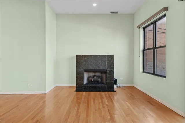 a view of an empty room with a fireplace and a window