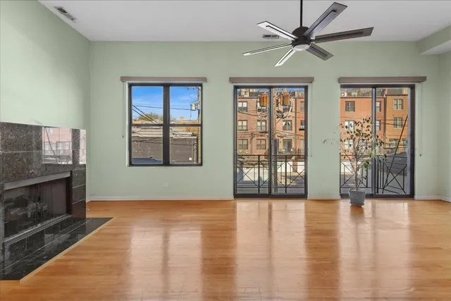 a view of an empty room with window and wooden floor