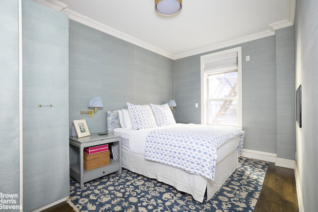 19 East 95th Street, Unit 4R Manhattan, NY 10128 - Photo 4 of 7 a bedroom with a bed and wooden floor