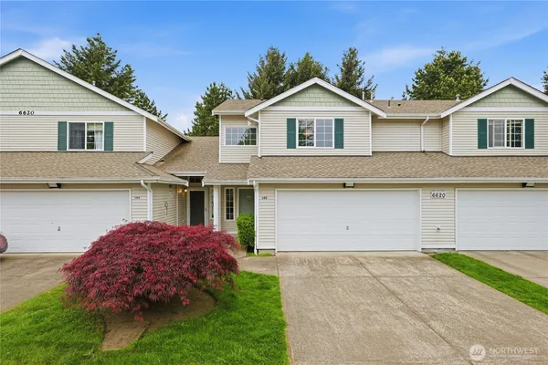 a front view of a house with a garden and garage