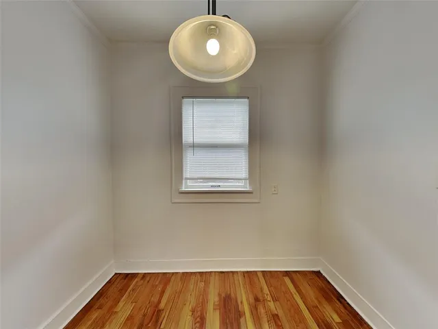 a view of a room with wooden floor and a window
