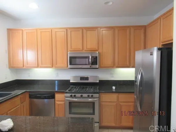 a kitchen with stainless steel appliances granite countertop a refrigerator stove and sink