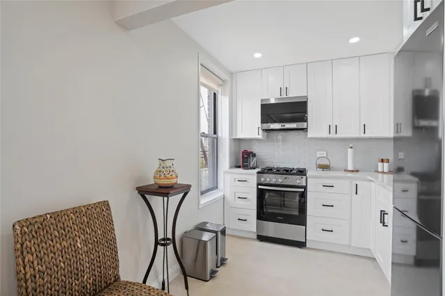 a kitchen with stainless steel appliances granite countertop a stove a sink and a microwave