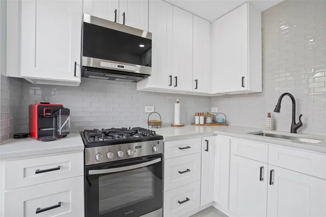 a kitchen with stainless steel appliances granite countertop a sink stove and cabinets