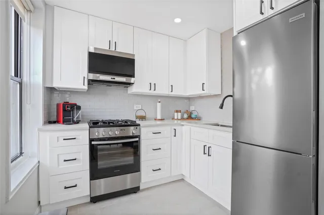 a kitchen with white cabinets and white appliances
