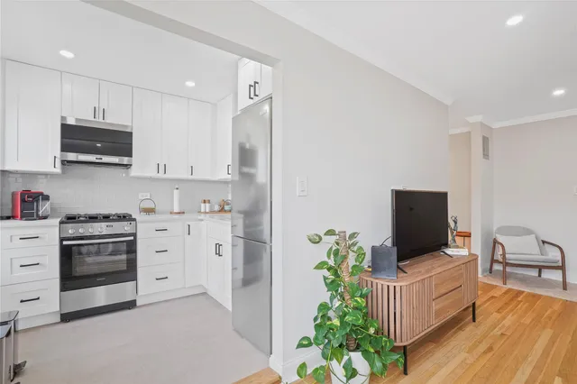 a kitchen with stainless steel appliances a stove a sink and a refrigerator