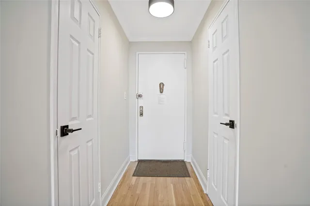 a view of a hallway with wooden floor and closet