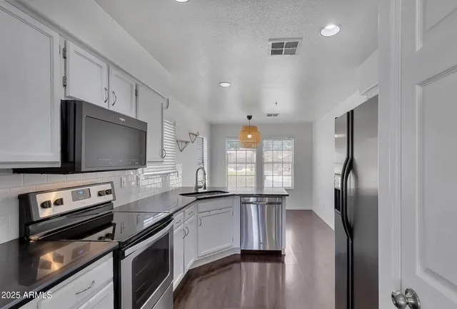 a kitchen with stainless steel appliances a stove sink and microwave