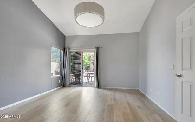 a view of an empty room with a window and wooden floor