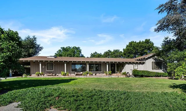 a front view of a house with a yard table and chairs