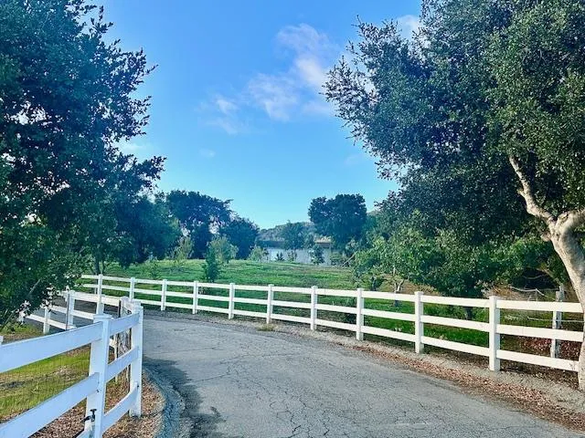 a view of a yard with wooden fence