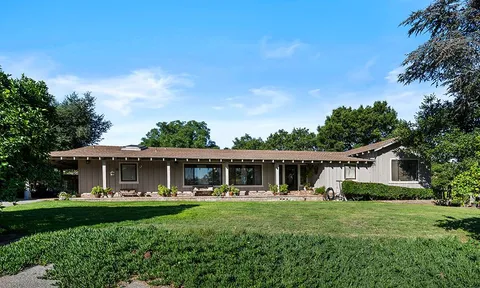 a front view of a house with a yard table and chairs
