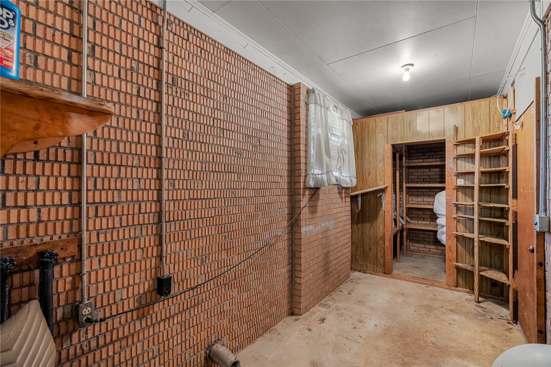 2101 Old Spring Drive Anderson, SC 29625 - Photo 20 of 36 Functional basement space with exposed brick walls, practical storage shelving, and concrete flooring.