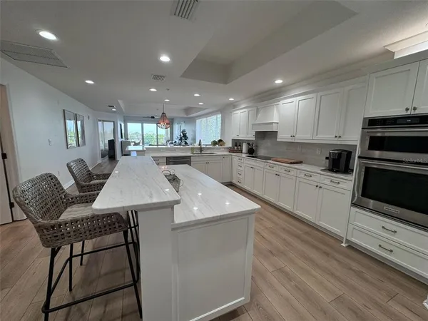 a dining room with furniture potted plants and wooden floor