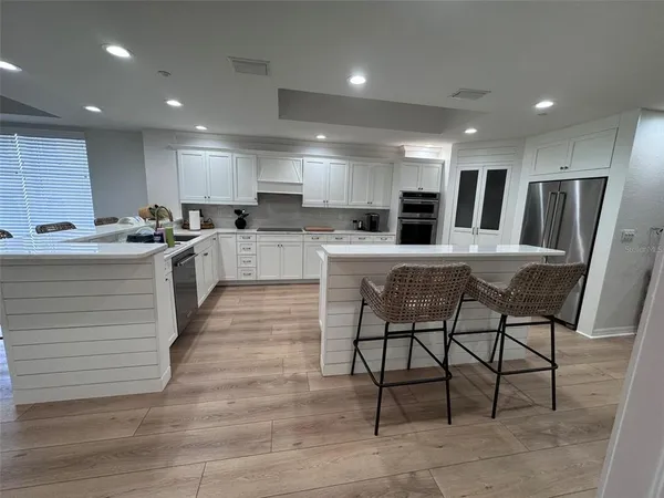 a kitchen with a sink an oven a refrigerator and a dining table