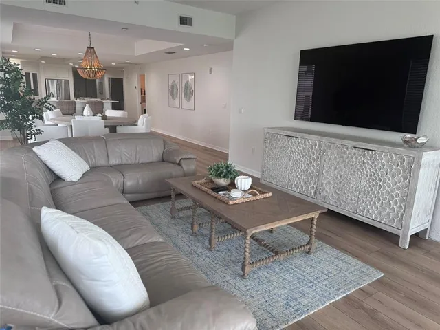 a spacious bedroom with a bed a couch and large window