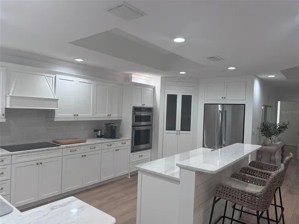 a large kitchen with kitchen island a sink table and chairs
