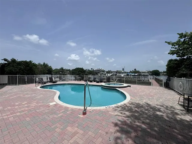 a view of a swimming pool with a chair and potted plants