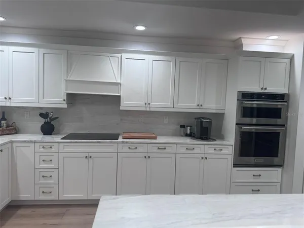 a kitchen with stainless steel appliances granite countertop a refrigerator and a stove top oven