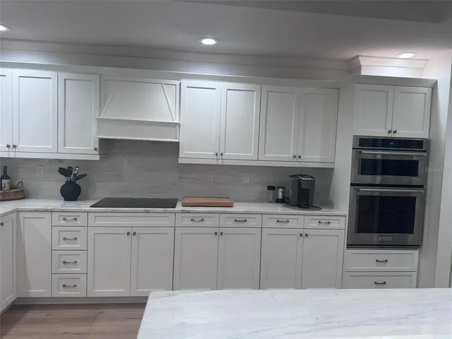 a kitchen with stainless steel appliances granite countertop a refrigerator and a stove top oven