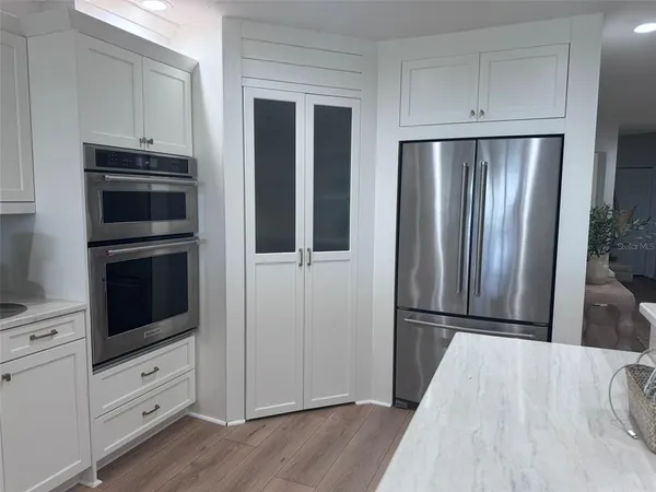 a kitchen with a table chairs microwave and cabinets