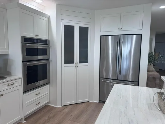 a kitchen with a table chairs microwave and cabinets