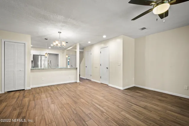 a view of an empty room with wooden floor