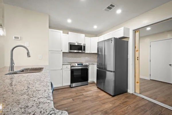 a kitchen with stainless steel appliances granite countertop a refrigerator sink and stove
