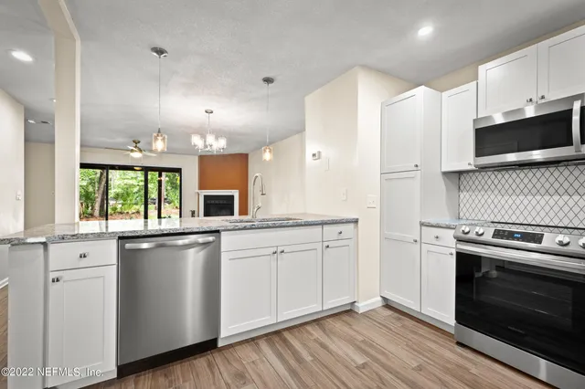 a kitchen with stainless steel appliances granite countertop a stove a sink and a microwave
