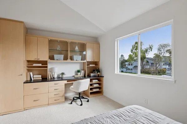 a view of a workspace with furniture and a window
