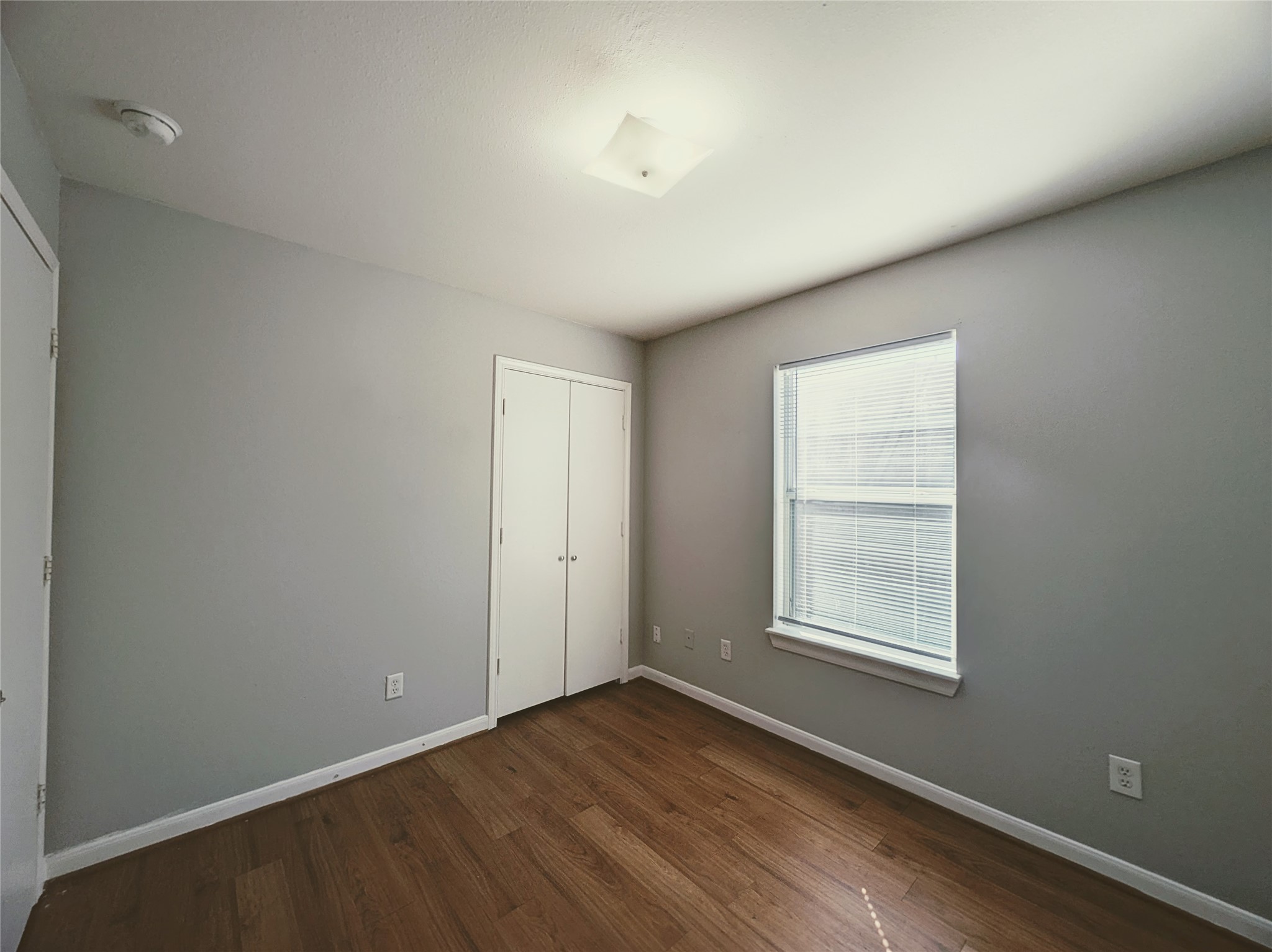 138 South Bend Court, Unit A Willis, TX 77378 - Photo 11 of 13 an empty room with wooden floor and windows