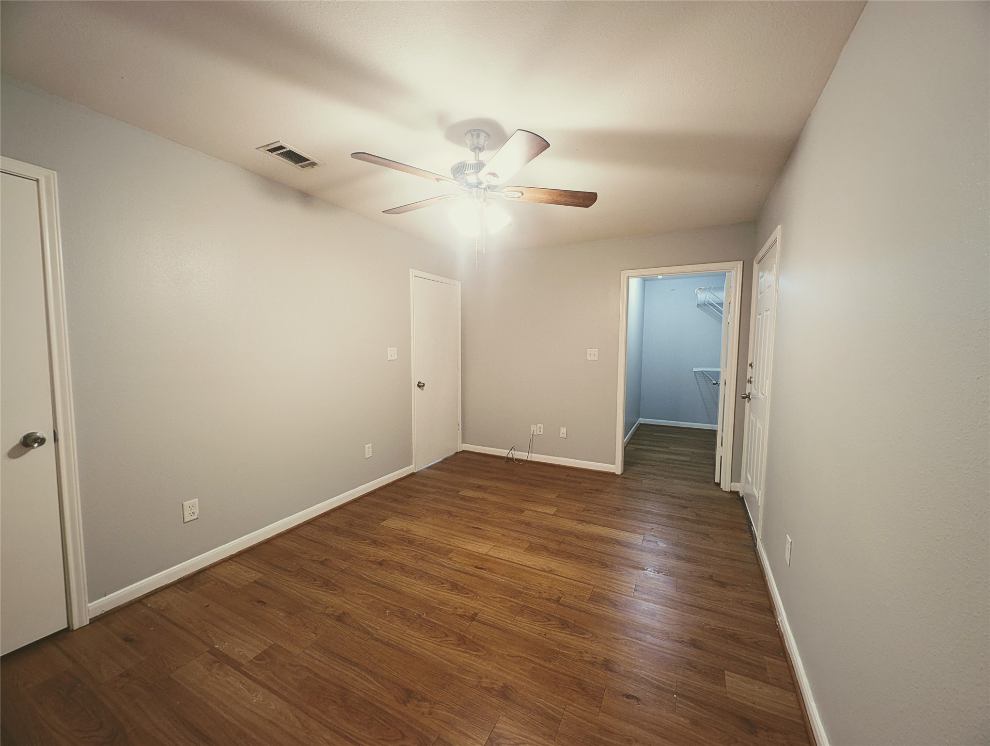 138 South Bend Court, Unit A Willis, TX 77378 - Photo 8 of 13 an empty room with wooden floor fan and windows