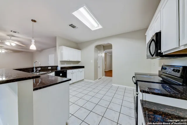 a kitchen with stainless steel appliances granite countertop a sink and a stove