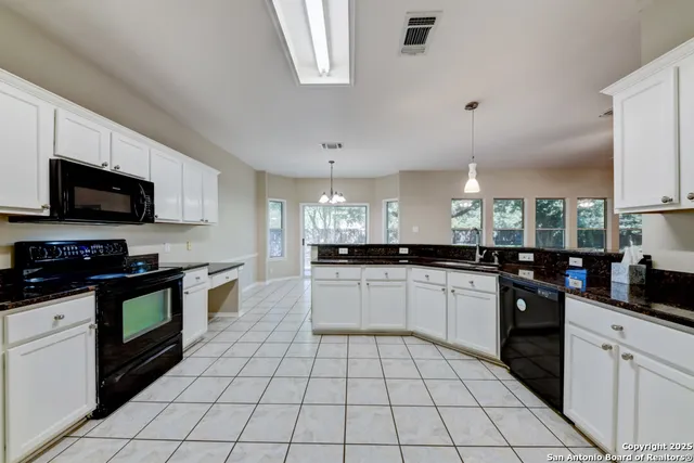 a kitchen with a sink a stove top oven and cabinets
